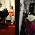 Election official Lori Shores, center left, shows Jan Copeland of Rogers how to use an electronic vo...