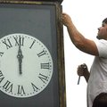 Josh Bonner with Wisdom's Clock Shop in Bentonville works on a restoration of the clock on the front...