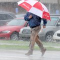 Joey Nelson sprints across Southwest Eighth Street during heavy morning rain in Bentonville on Frida...