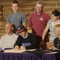 Elkins’ Hunter Guffey, center, signs a national letter of intent Wednesday to play basketball for th...