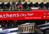 Tourists ride a bus in Athens on Thursday where hoteliers complained that raucous demonstrations against the Greek government’s plan to cut spending and raise taxes has prompted thousands of travelers to cancel trips.