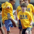 Shaw Elementary fifth-grader Felipe Nava, 11, left, passes the baton to teammate Matthew Burgin, 10,...