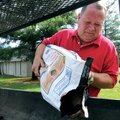 Benny Duncan loads charcoal into a grill Sunday at Rogers Christian Church. Duncan was preparing to ...