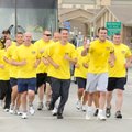 Bentonville police officers near the end of their six-mile run carrying the Flame of Hope Torch thro...