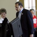 Election official Lora Bradford, left, helps start the electronic voting machine for John Boozman, R...