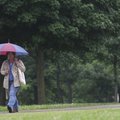 Karrie Larson of Fayetteville walks across the University of Arkansas campus Wednesday during a rain...