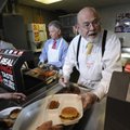 TO SERVE MAN - Collis Geren, right, keeps up with orders of baked beans Thursday during the Universi...