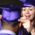 GRADUATES GEAR UP - Fayetteville High School senior Christa Duley, right, helps Sam Duru on Thursday...