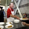 University of Arkansas Chancellor G. David Gearhart serves tacos to staff members Thursday at Donald...