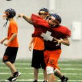 Rogers Heritage quarterback Reed Brown throws upfield during practice on Wednesday in Gates Stadium ...