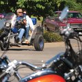 John and Lynn Ayres of Rogers ride their homemade trike Saturday into the parking lot of the Northwe...