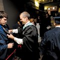 Jay Gilstrap, a drafting teacher at Rogers Heritage High School, right, helps graduating senior Came...