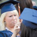 Camry Mathis, left, helps fellow Rogers Heritage High School graduating senior Caitlin Gayer with he...