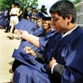Jesus Pulido writes his name on his mortarboard Saturday while waiting for Har-Ber’s commencement. P...