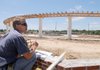 Superintendent Jim Thurman checks elevations of sidewalks Friday at Orchards Park in Bentonville. The 16-acre park on Northeast J Street is scheduled to be done by July 4.
