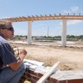 Superintendent Jim Thurman checks elevations of sidewalks Friday at Orchards Park in Bentonville. Th...