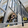 Kelly Paulk sweeps the stairway to the Benton County Courthouse in Bentonville on Monday. An auction...