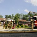 Rogers firefighters respond to a house fire at 503 S. 19th St. in Rogers on Monday. The house is own...