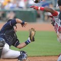 Northwest Arkansas catcher Manny Pina holds onto the ball for an out after colliding with Arkansas b...