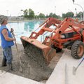 Dennis Ross, left, and Jose Cortez work new concrete Tuesday into a section of the deck around the m...