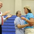 Virginia Mocivnik, center, hugs long-time friend Brenda Alexander as Mark Kruger, assistant principa...