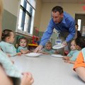 Paul Stone, senior vice president of Sam’s Club West Division, hands out plates to children Wednesda...