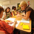 Adrienne Seeger, a second-grade teacher at Leverett Elementary School, helps Skyler Blickenstaff, le...