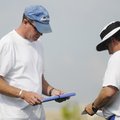 Rogers High assistant coach Cam Prock, left, looks over notes at practice Monday in Rogers.