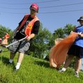  Gilbert Howell, left, and Katie Henderson work together to pick up trash Friday along Southeast 10t...