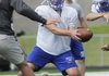  Rogers High’s Nick Wary hands off the ball during Monday’s practice in Mountie Stadium in Rogers.