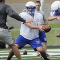  Rogers High’s Nick Wary hands off the ball during Monday’s practice in Mountie Stadium in Rogers.