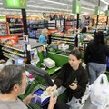 Walmart associate Tonya Sandefur hands a customer his change May 4 while running a checkout station ...