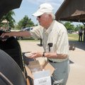  Stan Wiseman with the Springdale Lions Club gets a hotdog Saturday during the Lowell Lions Club Ice...