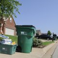 Danielle Tolbert puts her recycling and garbage outside her home Friday on Torrey Street in Springda...