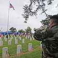 Greg Squirrel of Farmington plays taps Monday during a Memorial Day service at Fayetteville National...