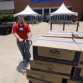 Jacob Hutson of Bentonville loads a pallet of potato chips Tuesday into Bud Walton Arena in Fayettev...