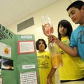 Miguel Juarez, 10, right, and sister Hitzel Juarez, 16, center, create a water tornado inside a pair...