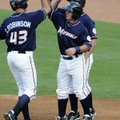 Northwest Arkanasas’ Clint Robinson, left, is met at the plate by teammates Mike Moustakas, rear, an...