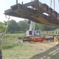 James Auxier guides a 21-ton railroad flatcar into place place during construction of a bridge over ...