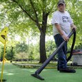 POWER VACUUM - Chris Nichols vacuums water out of the green on the No. 14 hole Thursday at Lakeside ...