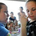 Courtney Stone, 10, of Magazine has her face painted by Mary Munford on Saturday before the start of...