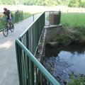 A biker rides on a bridge over Town Branch Creek along the North Bentonville Trail on June 2. The En...