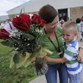 Wendy McCain, a Holcomb Elementary School teacher, gets a flower bouquet and a goodbye hug Monday fr...
