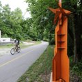 A cyclist rides past the sculpture “city fragments” Monday on the Frisco Trail in Fayetteville. Faye...