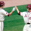 Arkansas’ Collin Kuhn is greeted at home plate by teammate Brett Eibner on March 20, 2010, after hit...