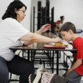 Angela Furnish, left, helps her son, Matthew, 7, put mustard on his sandwich Thursday during the sum...