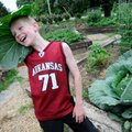 BIG GREEN - Connor Klein, 9, tries a leaf on for size from the 19.6-pound cabbage he harvested Satur...