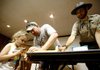 Park Interpreter Adam Leslie (right) helps Greg Spencer and his daughter, Abigail Spencer, 4, both of Ardmore, Okla., build a bat house Saturday during Bat-O-Rama at Devil’s Den State Park.
