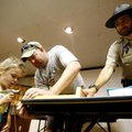 Park Interpreter Adam Leslie (right) helps Greg Spencer and his daughter, Abigail Spencer, 4, both o...