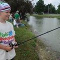 FISHY FUN - Caleb Summey, 8, of Rogers, fishes Saturday during the Rogers Optimist Club Fishing Derb...
